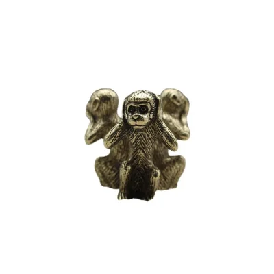 Solid copper three wise monkeys on a plain white studio background